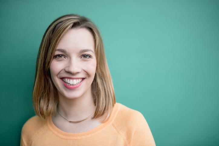 Portrait of a smiling young woman on green